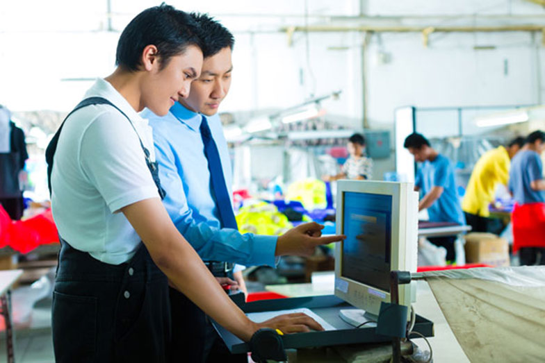 factory workers at computer screen