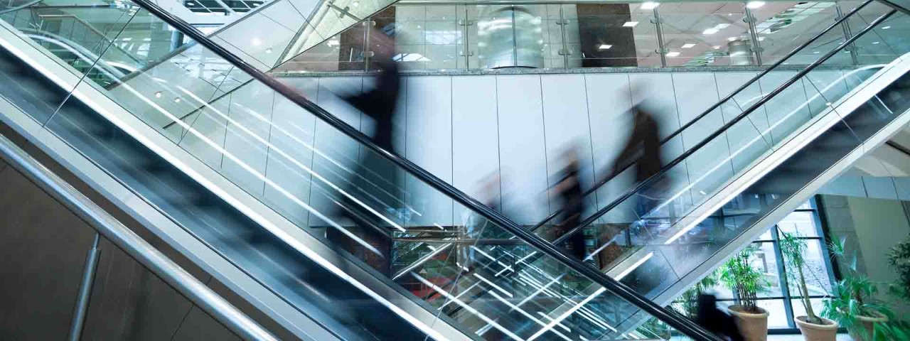 blurred view of people on escalators