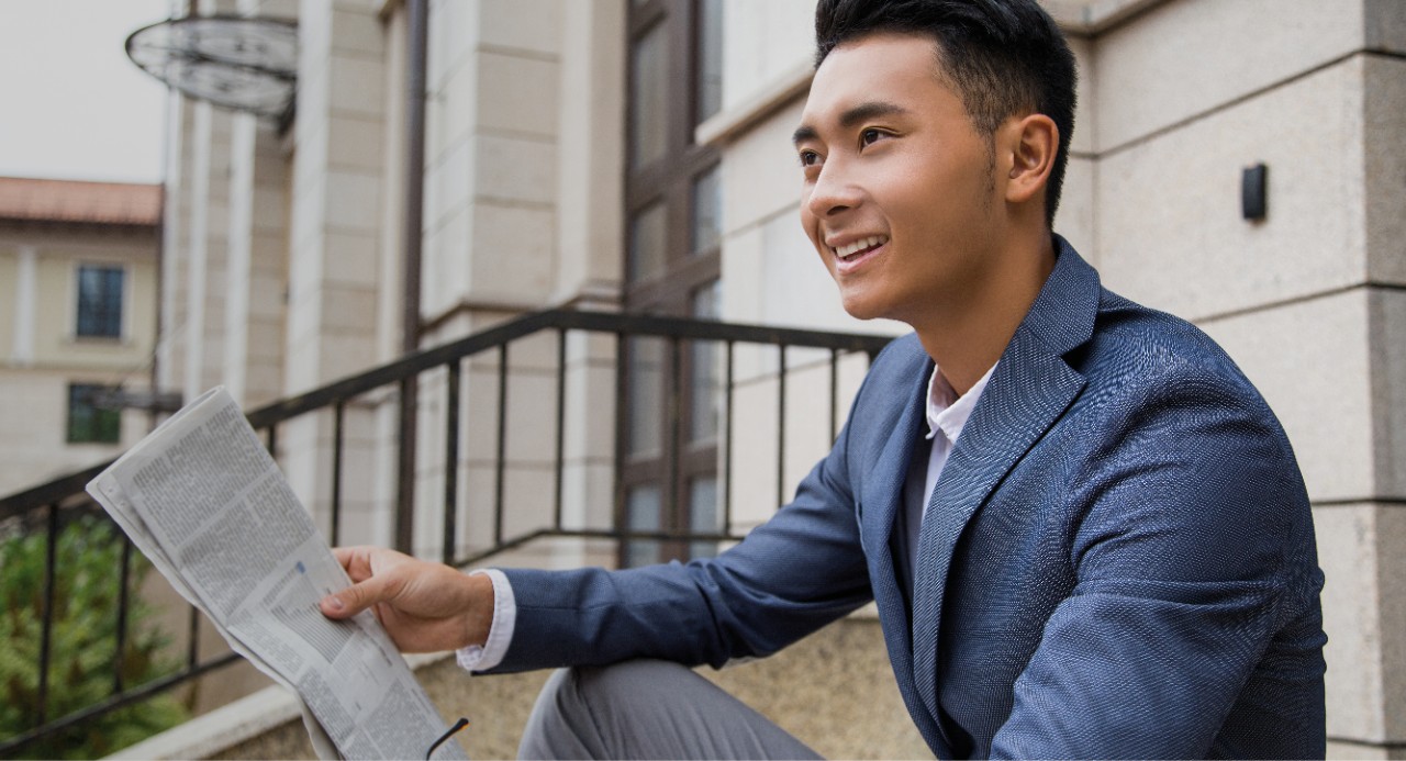 man sitting on steps holding documents