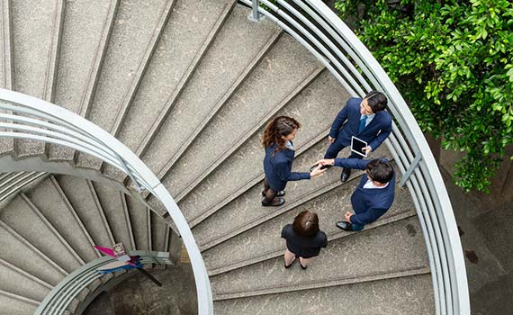 A group of young finance professionals talking on an outside Hong Kong SRA of China staircase