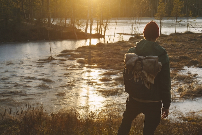 Finland, Esbo, Kvarntrask, Young man standing on marshy lakeshore Finland, Esbo, Kvarntrask, Young man standing on marshy lakeshore