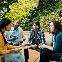 GROUP OF PEOPLE SITTING ON MOBILE PHONE IN PARK