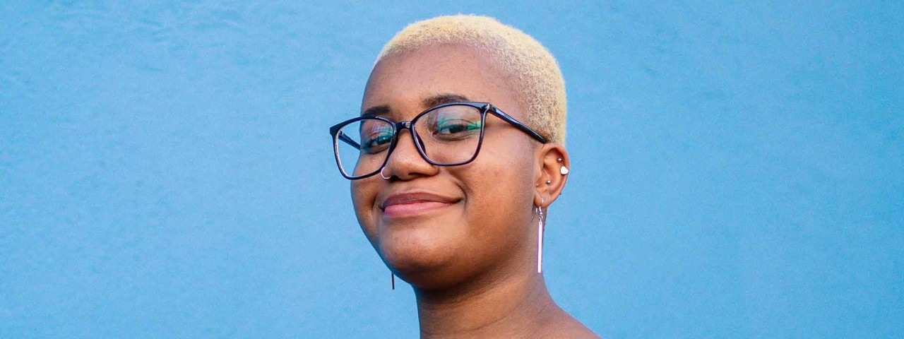 person smiling against a blue background
