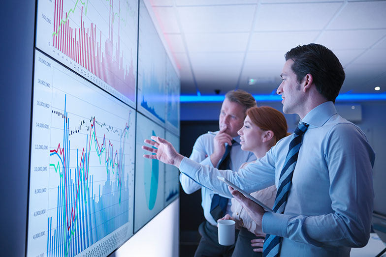 Colleagues looking at data on a large screen