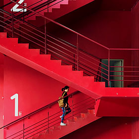 person walking up red stairs